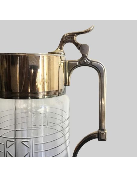 Detailed view of the silver fittings of the handle and hinged lid of the large Art Nouveau crystal jug with cooling insert